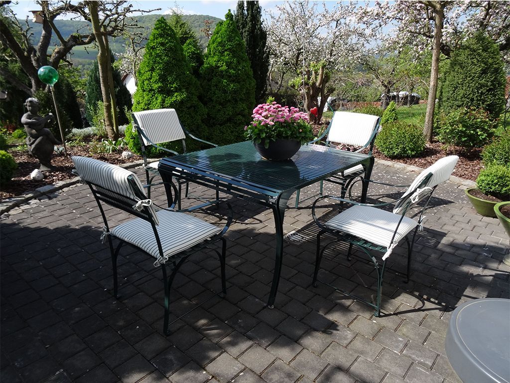 harmonische Komination von Gartentisch und Gartenstuhl aus Edelstahl im Garten