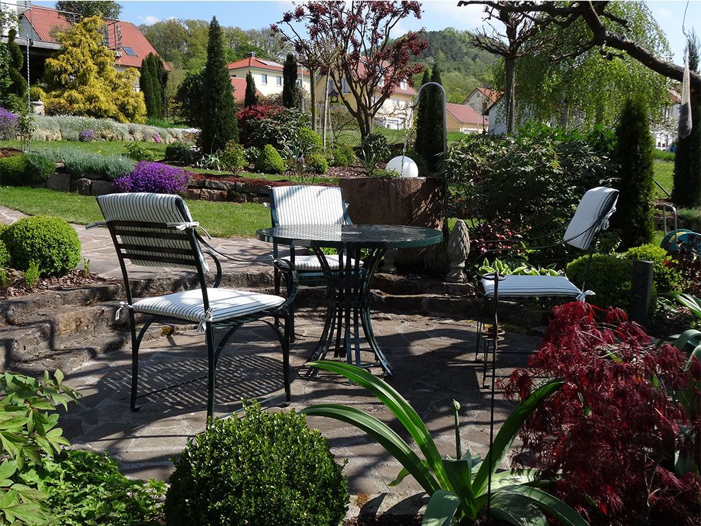 harmonische Komination von Gartentisch und Gartenstuhl aus Edelstahl im Garten