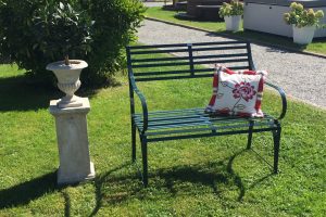 Polster mit grüner Edelstahl Gartenbank Cannes